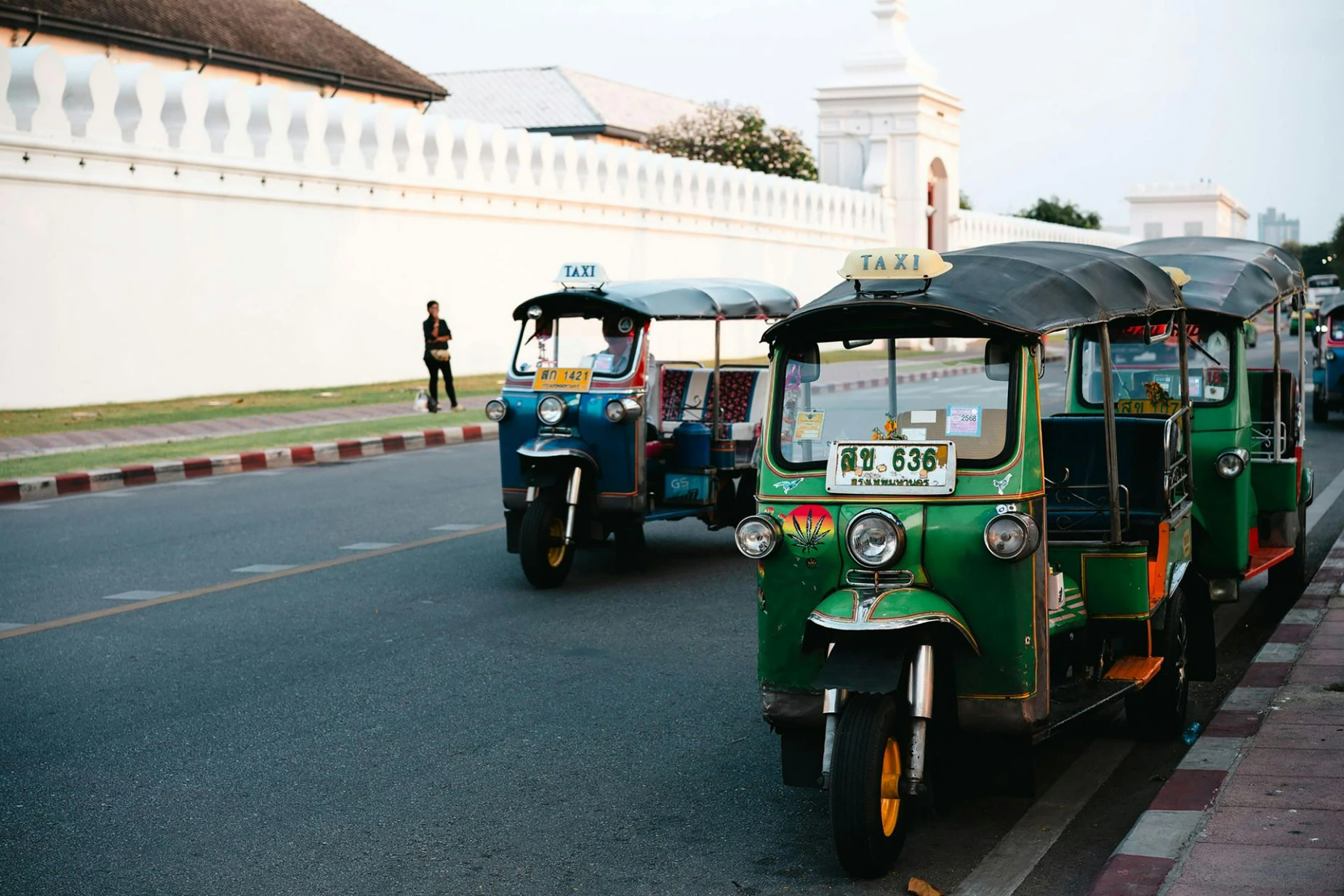 Colorful Tuk-Tuks by White Wall in Bangkok Street