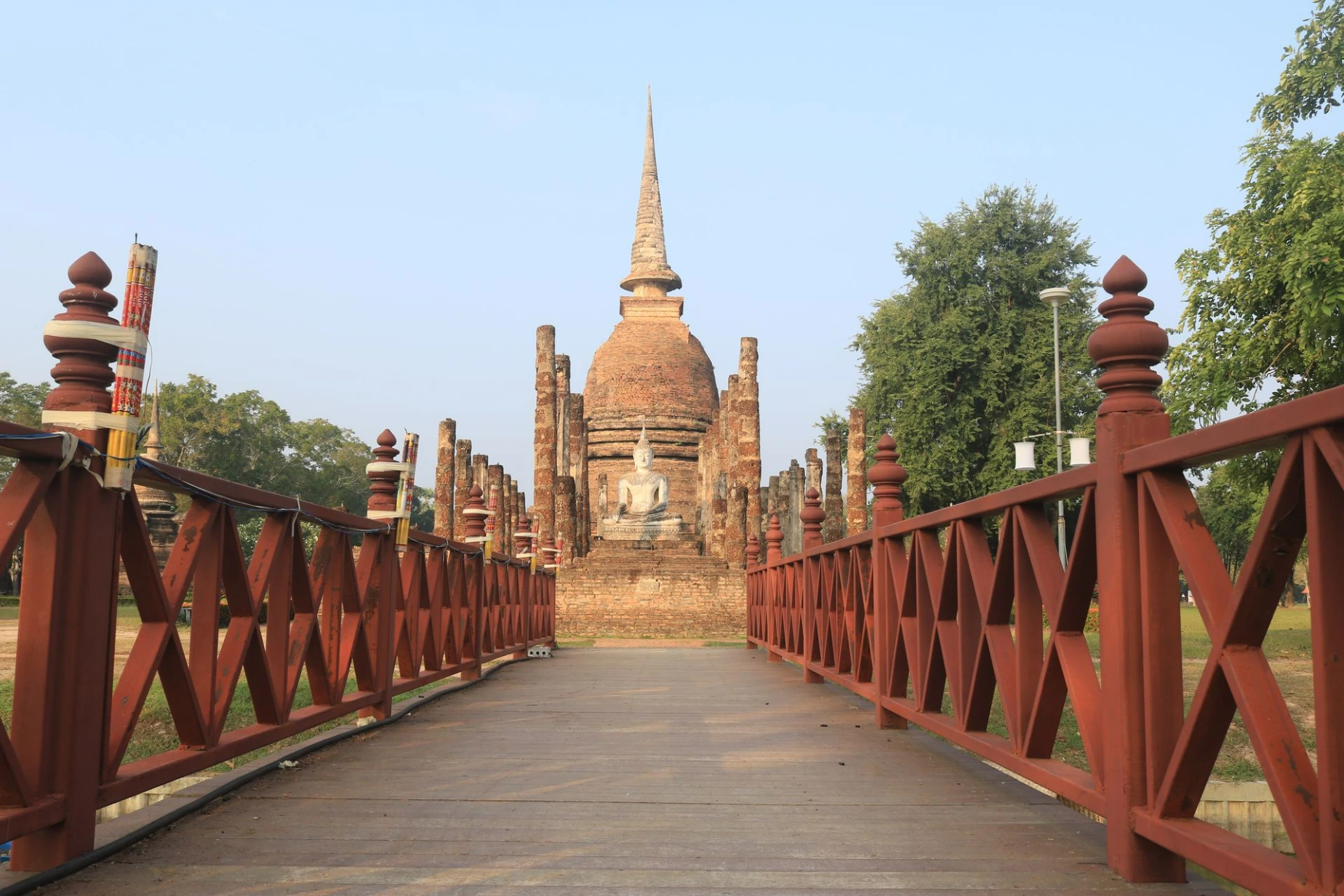 Buddha statue in front of ancient pagoda in Sukhothai Historical Park